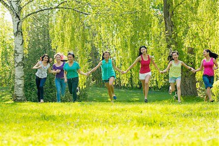 preteen girls in park - People running in park holding hands Stock Photo - Premium Royalty-Free, Code: 614-07031205