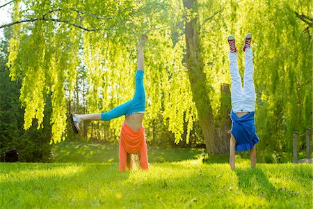 Two girls doing handstands in park Foto de stock - Sin royalties Premium, Código: 614-07031220