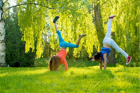 erba - Two girls doing handstands in park Fotografie stock - Premium Royalty-Free, Codice: 614-07031221