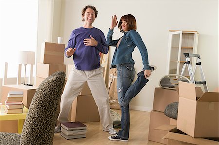 stack white shirt - Couple having fun dancing whilst moving house Stock Photo - Premium Royalty-Free, Code: 614-07031335