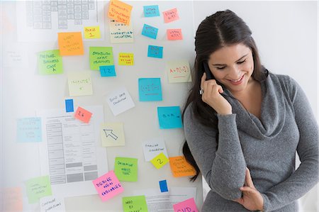 sticky notes - Portrait of female office worker using mobile Stock Photo - Premium Royalty-Free, Code: 614-07031389