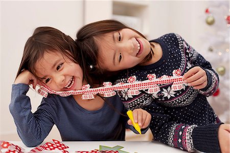 Girls holding Christmas decorations, laughing Foto de stock - Sin royalties Premium, Código: 614-07031483