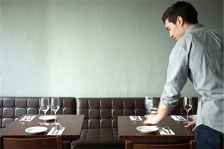 setting table and one person - Waiter setting table in restaurant Stock Photo - Premium Royalty-Free, Code: 614-07031506