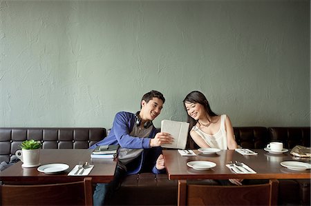 Young man showing young woman digital tablet in restaurant Foto de stock - Sin royalties Premium, Código: 614-07031500
