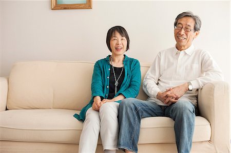 east asian ethnicity - Senior couple sitting on sofa, portrait Stock Photo - Premium Royalty-Free, Code: 614-07031604