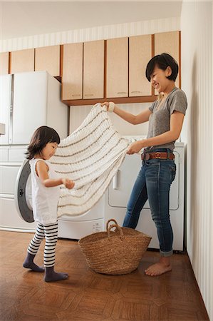 folded towels - Mother and daughter folding towel Stock Photo - Premium Royalty-Free, Code: 614-07031656