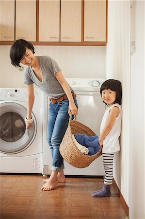 parent carrying child - Mother and daughter with laundry basket Stock Photo - Premium Royalty-Free, Code: 614-07031664