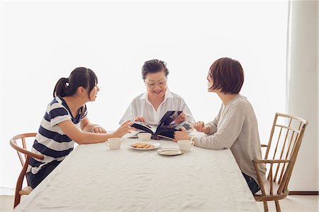 Three generation family looking at photograph album Photographie de stock - Premium Libres de Droits, Code: 614-07031668