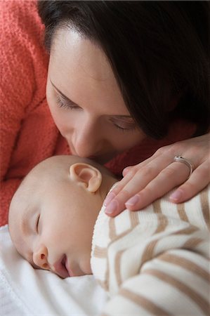 exhausted mother with baby - Mid adult woman kissing baby son, close up Stock Photo - Premium Royalty-Free, Code: 614-07031698