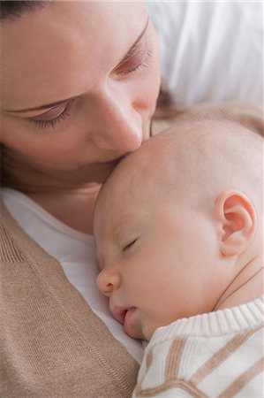 exhausted mother with baby - Mid adult mother kissing baby boy Stock Photo - Premium Royalty-Free, Code: 614-07031706