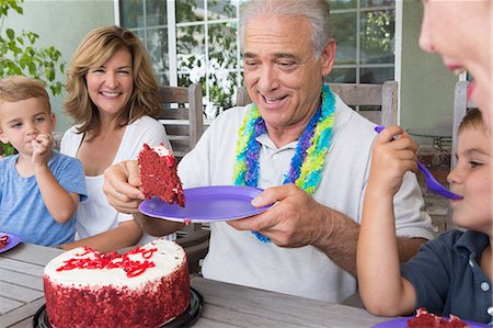 Senior man serving slice of birthday cake at party with family Photographie de stock - Premium Libres de Droits, Code: 614-07031714
