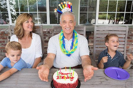 senior woman with cake - Senior man with birthday cake and family, portrait Stock Photo - Premium Royalty-Free, Code: 614-07031734