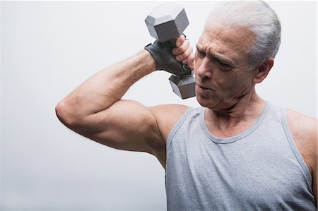 Senior man lifting dumbbell Foto de stock - Sin royalties Premium, Código: 614-07031737