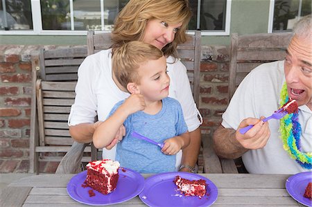 family with grandparents eating - Grandson and mother watching senior man eat birthday cake Foto de stock - Sin royalties Premium, Código: 614-07031732