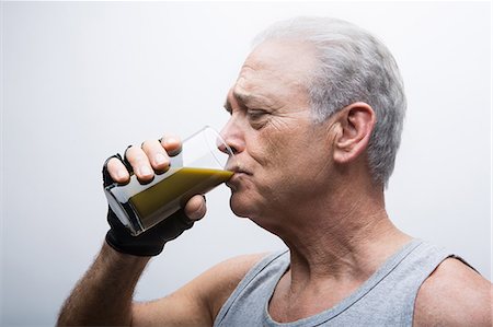 drinking milk shake - Senior man drinking smoothie from glass Stock Photo - Premium Royalty-Free, Code: 614-07031744