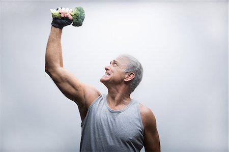 people holding broccoli - Senior man looking up and lifting broccoli Stock Photo - Premium Royalty-Free, Code: 614-07031740