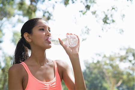 peach color - Young woman drinking from water bottle Stock Photo - Premium Royalty-Free, Code: 614-07031774