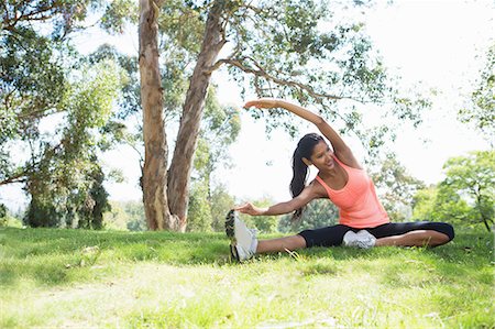 Young woman stretching in park Stock Photo - Premium Royalty-Free, Code: 614-07031775
