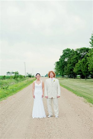 Portrait of couple on wedding day standing on dirt track Stock Photo - Premium Royalty-Free, Code: 614-07031811