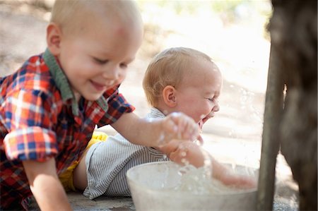 Toddler twins splashing in bowl of water Foto de stock - Royalty Free Premium, Número: 614-07031828