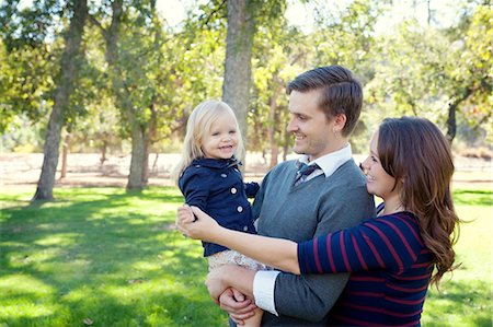 father mother kid holding hands in park - Young parents in park holding female toddler Stock Photo - Premium Royalty-Free, Code: 614-07031836