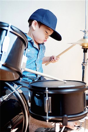 Male toddler playing drum kit Foto de stock - Sin royalties Premium, Código: 614-07031847