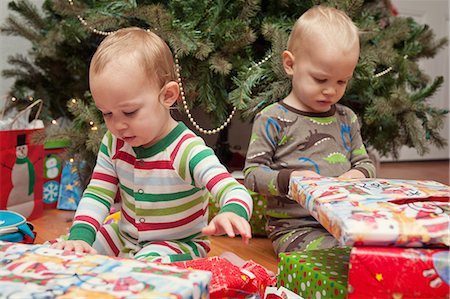 Brother and sister looking at Christmas presents Stock Photo - Premium Royalty-Free, Code: 614-07031880