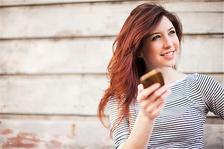 smartphone outdoors - Portrait of young woman with smartphone Stock Photo - Premium Royalty-Free, Code: 614-07031917