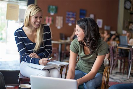 Two teenagers studying with textbooks and computer in cafe Stock Photo - Premium Royalty-Free, Code: 614-07031982