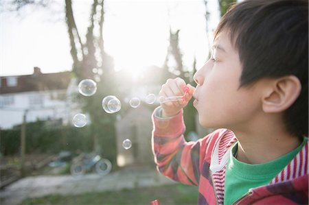 fun bubble - Boy blowing bubbles with wand, close up Stock Photo - Premium Royalty-Free, Code: 614-07032012