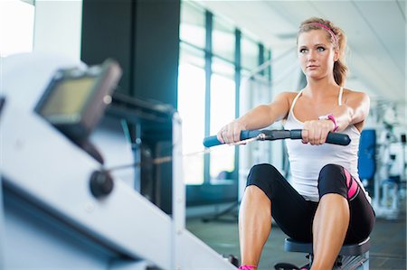 fitness caucasian - Young woman using rowing machine in gym Stock Photo - Premium Royalty-Free, Code: 614-07032153