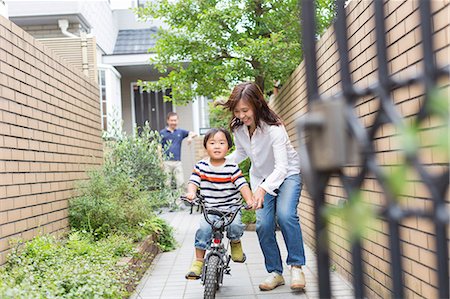 simsearch:614-07145838,k - Mother helping son to ride a bike Photographie de stock - Premium Libres de Droits, Code: 614-07145841