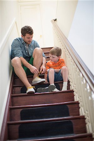 Father and son sitting on stairs tying shoelaces Stockbilder - Premium RF Lizenzfrei, Bildnummer: 614-07145879