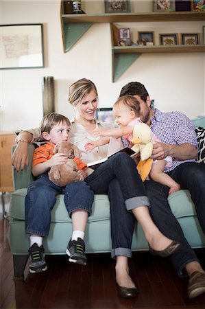 four - Parents with two children sitting on sofa Stock Photo - Premium Royalty-Free, Code: 614-07145897