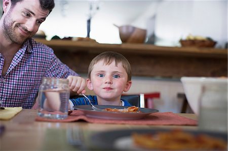 displeased - Father with son eating dinner Stock Photo - Premium Royalty-Free, Code: 614-07145917