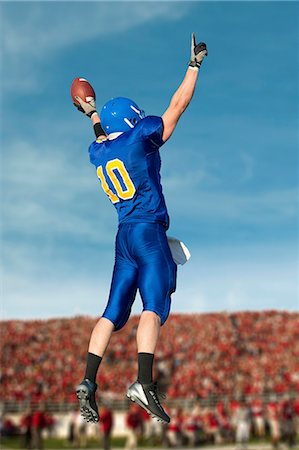 football - American footballer jumping with ball Stock Photo - Premium Royalty-Free, Code: 614-07146101