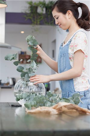 flowers vase above - Young woman selecting foliage for vase arrangement Stock Photo - Premium Royalty-Free, Code: 614-07146144