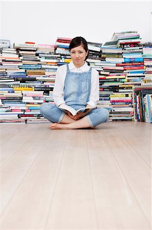 Young woman crossed legged on floor in front of book pile Photographie de stock - Premium Libres de Droits, Code: 614-07146154