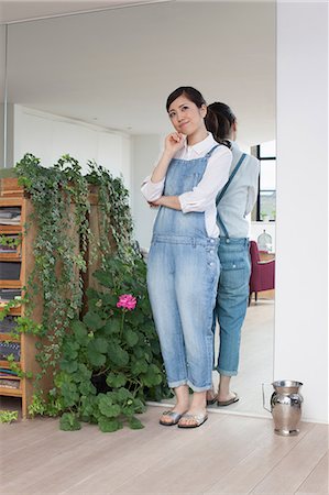 Young woman in living room thinking Stock Photo - Premium Royalty-Free, Code: 614-07146153