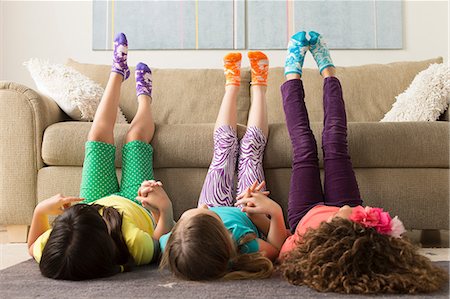 Three girls lying on floor with legs up Stock Photo - Premium Royalty-Free, Code: 614-07146295