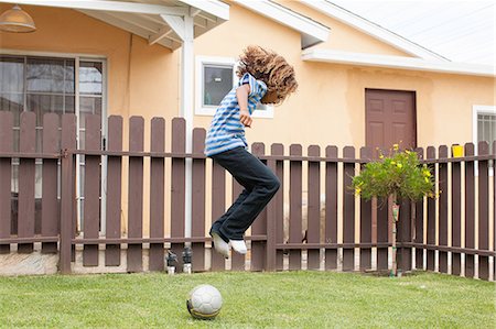 Boy jumping over football Foto de stock - Sin royalties Premium, Código: 614-07146333