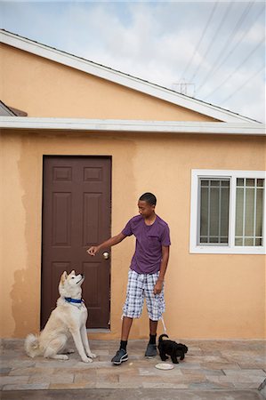 simsearch:614-07146362,k - Boy outside house with two dogs Fotografie stock - Premium Royalty-Free, Codice: 614-07146352