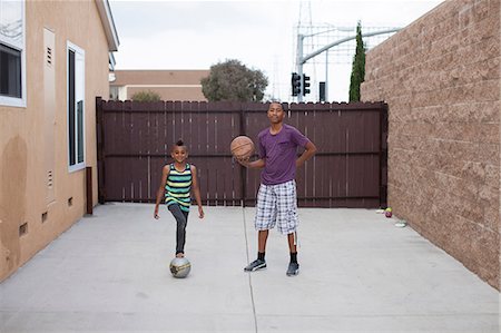 simsearch:614-07146362,k - Two boys in yard with basketball and football Fotografie stock - Premium Royalty-Free, Codice: 614-07146365