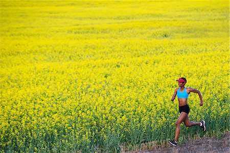 simsearch:614-06336230,k - Young woman running next to oil seed rape field Stock Photo - Premium Royalty-Free, Code: 614-07146379