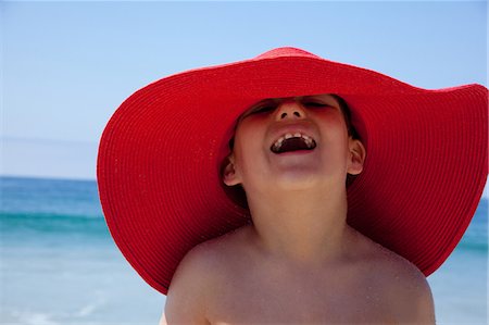 summer beach kids - Young boy in large red sunhat Stock Photo - Premium Royalty-Free, Code: 614-07146400