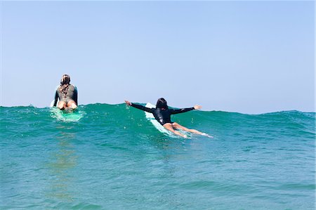 surfer beach - Female friends surfing, Hermosa Beach, California, USA Stock Photo - Premium Royalty-Free, Code: 614-07146453