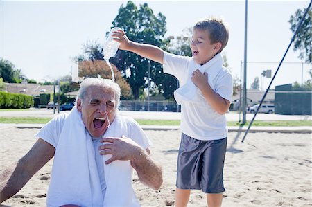 seniors with grandkids - Boy pouring water on grandfather Stock Photo - Premium Royalty-Free, Code: 614-07146506