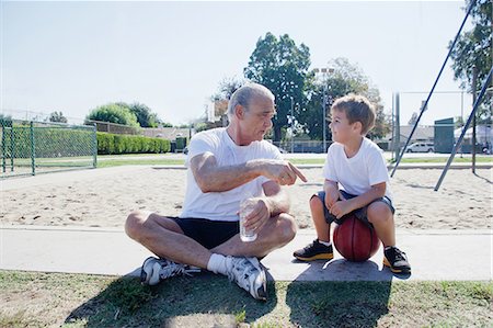 photos of boys short pants - Man giving grandson basketball pep talk Stock Photo - Premium Royalty-Free, Code: 614-07146507