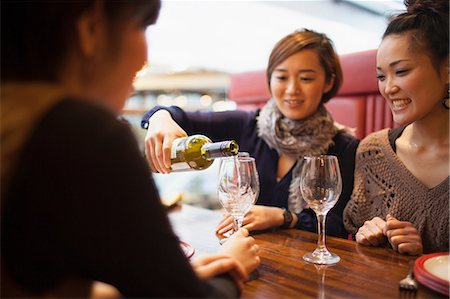 Young woman pouring wine in restaurant Foto de stock - Royalty Free Premium, Número: 614-07146544