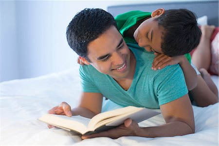 Father and son reading on bed Foto de stock - Sin royalties Premium, Código: 614-07146570